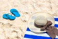 Straw hat, towel and flip flops on sand beach Royalty Free Stock Photo