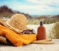 Straw hat with towel and lotion Royalty Free Stock Photo