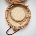 Straw hat trimmed in dried flowers inside of woven basket