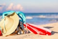 Straw hat, umbrella and blue bikini bra swimsuit with beach bag against the ocean beach with beautiful blue sky and clouds. Royalty Free Stock Photo