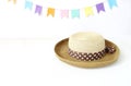 Straw hat on white table with colorful party flags, bunting decoration. Greeting card, invitation for summer birthday or Royalty Free Stock Photo