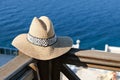 Straw hat with on wooden terrace of holiday villa or hotel with sea view Royalty Free Stock Photo