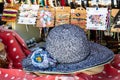 Straw hats background. Closeup with selective focus on a blue woman straw beach sun hat with flower for sale with blurred market