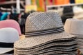 Straw hats background. Closeup with selective focus on a stack straw hats for sale with blurred market shop background. Macro