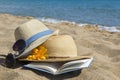 Straw hats, sunglasses and a book on the beach. Summer vacation Royalty Free Stock Photo