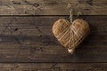 Straw heart hanging on a nail on a wooden wall, rustic style Royalty Free Stock Photo