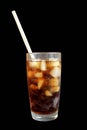 Dark soda cola with ice in a glass with straws on a black background Royalty Free Stock Photo