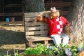 A straw man resting on garden bench, garden sculpture