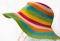 Straw multi-color summer hat on white background. Elegant hat with wide margins. Women beach, colorful stripped hat