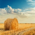 Straw rolls on agriculture field after harvesting in sunset Royalty Free Stock Photo