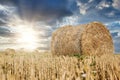 Straw rolls, straw bale on farmer field and sunset with dramatic cloudy sky, beautiful nature after harvest Royalty Free Stock Photo