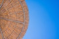 Straw roof of sun umbrella against the blue sky. Vacation topic.summer beach, background for an inscription.Texture of Royalty Free Stock Photo