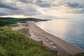 Straw sunshades and sunbeds on the empty sandy beach Royalty Free Stock Photo