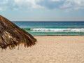 Straw umbrella on a blue-green water beach in Cancun, Mexico Royalty Free Stock Photo