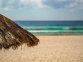 Straw umbrella on a blue-green water beach in Cancun, Mexico wit Royalty Free Stock Photo