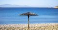 Straw umbrella on an empty sandy beach. Blue sea and sky background Royalty Free Stock Photo