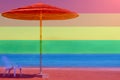 A straw umbrella and a white chair stand on a sandy beach near the water. .... LGBT natural pattern, Vintage texture background, A Royalty Free Stock Photo