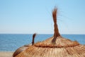 Straw umbrellas on the beach with the Mediterranean sea Royalty Free Stock Photo