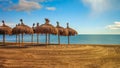 Straw umbrellas on empty mediterranean beach