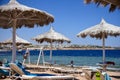 Straw umbrellas and white sunbeds on the white sand beach, summer rest background Royalty Free Stock Photo