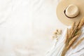 straw weaved hat with dry leaves and wild flowers. Bohemian background, boho flat lay composition Royalty Free Stock Photo