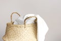 Straw wicker basket and white natural cotton fabric, towel on gray background. Fashionable bamboo basket stylish interior item eco Royalty Free Stock Photo