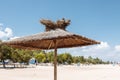 Straw and wooden umbrella on an empty beach background, Sunny day, place for text Royalty Free Stock Photo