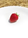 Strawberrie on white plate and straw background Royalty Free Stock Photo