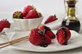 Strawberries with balsamic vinegar drops behind with whole strawberries