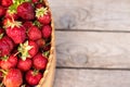 strawberries in a basket on a wooden background, empty space Royalty Free Stock Photo