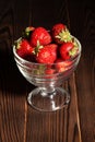 Strawberries bowl on dark wood