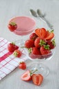 Strawberries in a bowl with a towel and two spoons