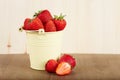 Strawberries in a bucket on wooden table Royalty Free Stock Photo