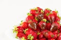 Strawberries dipped in delicious chocolate in white dish isolated on white background. Close up view. Royalty Free Stock Photo