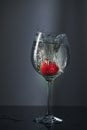 Strawberries dropped into a glass of water and splashes of water on a black table Royalty Free Stock Photo