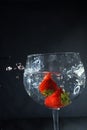 Strawberries dropping to a glass water splash Royalty Free Stock Photo