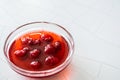 Strawberries float to jam in a small bowl