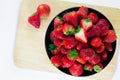 Strawberries fresh in a black cup on a wooden plate with a whit Royalty Free Stock Photo