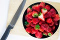 Strawberries fresh in a black cup on a wooden plate with a whit Royalty Free Stock Photo