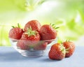 Strawberries in a glass bowl on a table outside