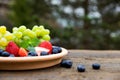 Strawberries, grapes and blueberries on wooden table, outside Royalty Free Stock Photo