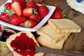 Strawberries jam with rusk on wooden table