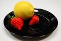 Strawberries and lemon in a black plate Royalty Free Stock Photo