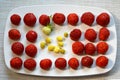 Strawberries lie in a row on a plate. The view from the top. Red and yellow berries close-up. Not like everyone else