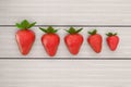 Strawberries lying on white table in row order. Line of strawberry on the white wooden table, 3d illustration.