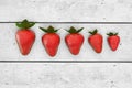 Strawberries lying on white table in row order. Line of strawberry on the white wooden table, 3d illustration.