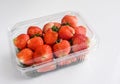 Strawberries in packaging, white background.