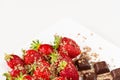 Strawberries and pieces of chocolate in white dish isolated on white background. Close up view. Royalty Free Stock Photo