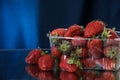 Strawberries in a plastic box closeup under the water drops in a dark blue background. Healthy lifestyle. Multivitamin cocktail. Royalty Free Stock Photo