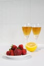 Strawberries on a plate, lemon, juice in glasses